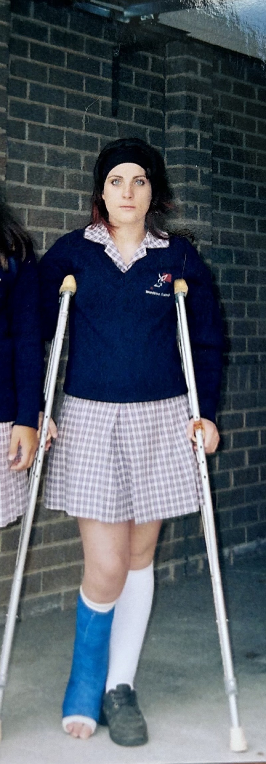 School uniform, crutches and a cast